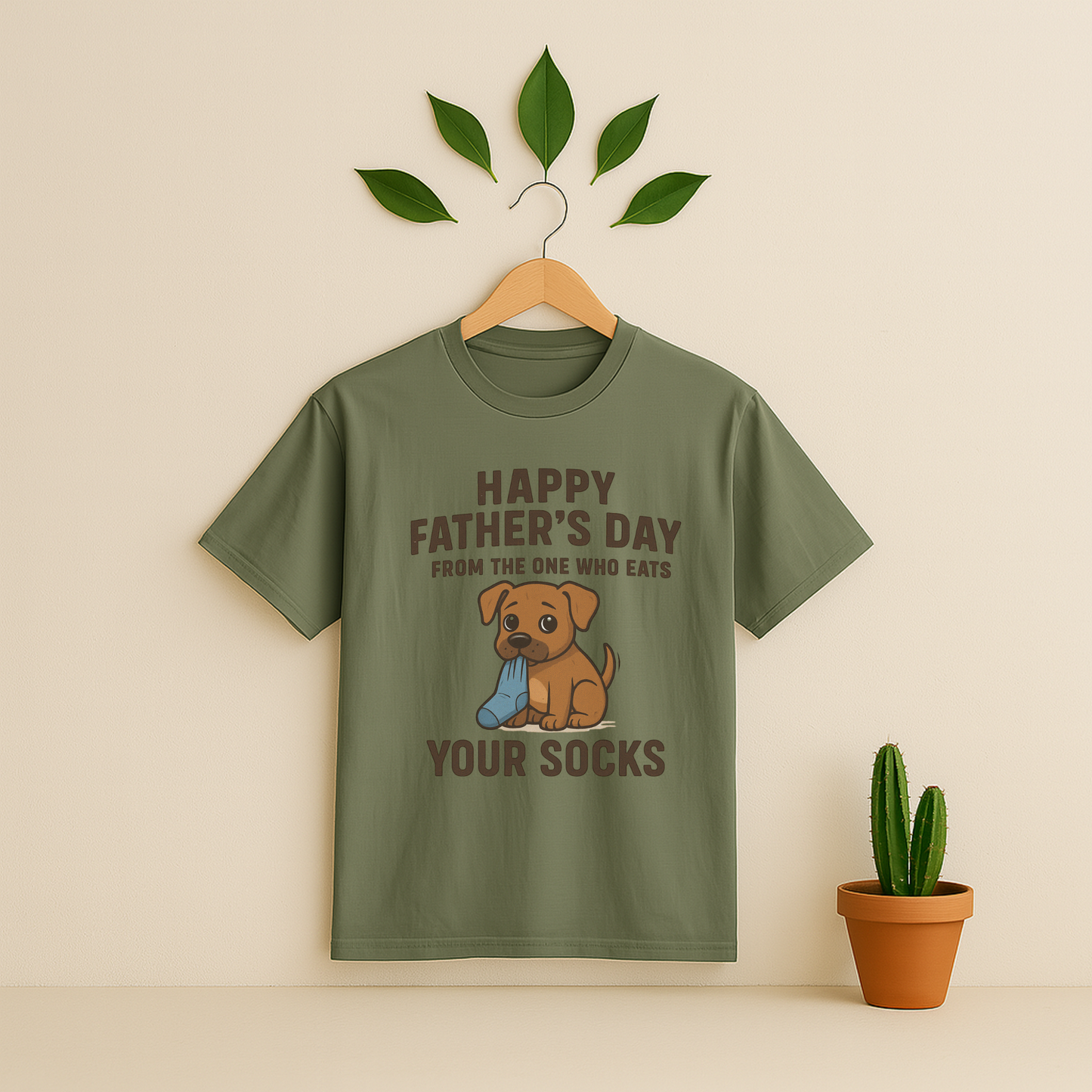 Moss t-shirt with graphic antd text on a wooden hanger against a beige background with a cactus plant.