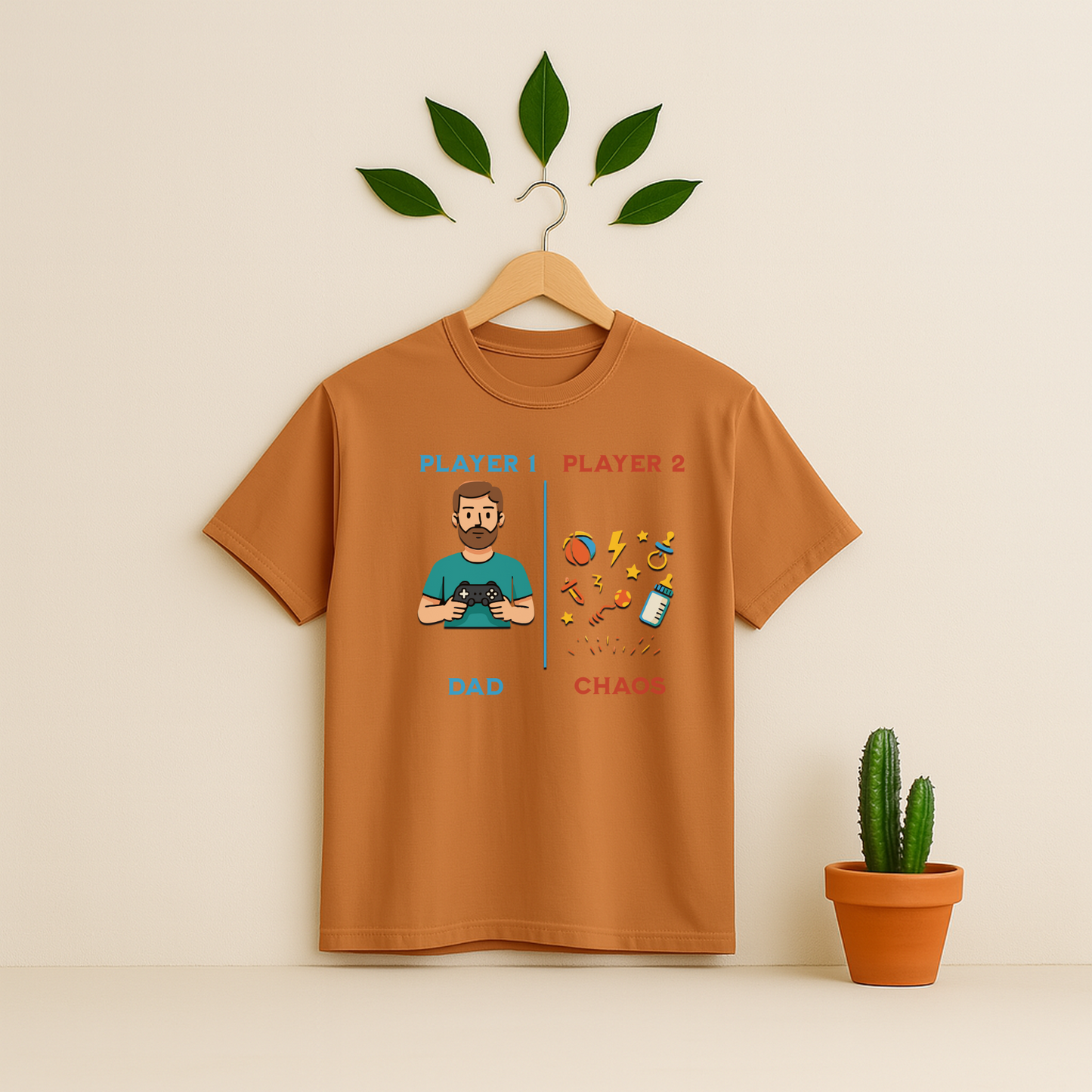 Yam t-shirt with 'Player 1 & Player 2 Dad' graphic on a wooden hanger against a beige background with a cactus plant.